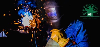 Boilermaker welding a steel plate wearing yellow protective gloves, Artisan Training Institute