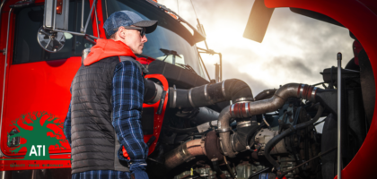 Diesel mechanic apprentice inspecting an open truck engine bay, Artisan Training Institute