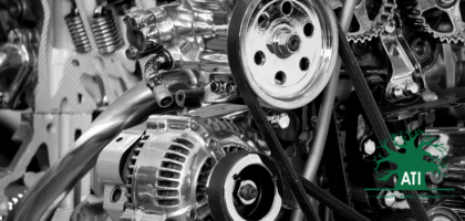 Close-up of a heavy equipment engine bay showing the alternator, drive belts and hydraulic hoses, representing Heavy Equipment Mechanic training at Artisan Training Institute