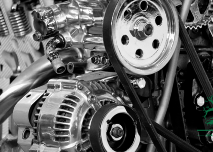 Close-up of a heavy equipment engine bay showing the alternator, drive belts and hydraulic hoses, representing Heavy Equipment Mechanic training at Artisan Training Institute